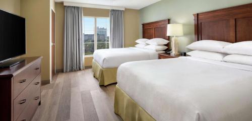 德斯坦Embassy Suites by Hilton Destin Miramar Beach的酒店客房设有两张床和一台平面电视。