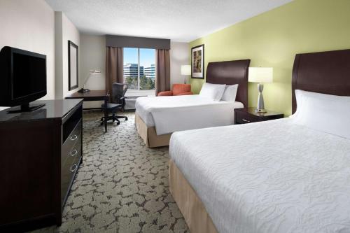 高原牧场Hilton Garden Inn Denver Highlands Ranch的酒店客房设有两张床和一台平面电视。