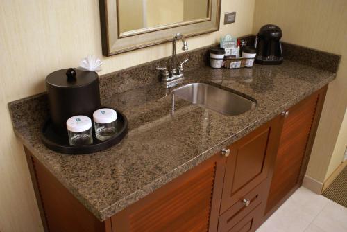 森特尼尔Embassy Suites Denver Tech Center的厨房柜台设有水槽和镜子