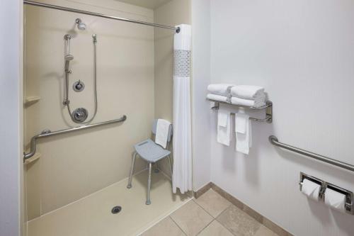 赛普里斯Hampton Inn Los Angeles Orange County Cypress的带淋浴的浴室和椅子