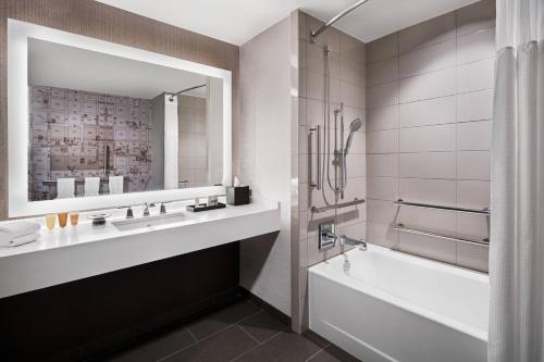 罗利州景傲途格精选酒店的带浴缸、水槽和镜子的浴室