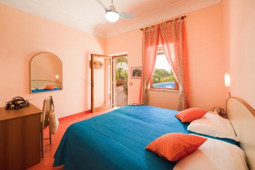 伊斯基亚Hotel Villa Sirena的一间卧室设有蓝色的床和窗户。