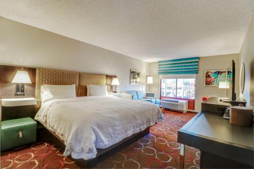 拉斯维加斯Hampton Inn Tropicana的酒店客房设有一张大床和一张书桌。