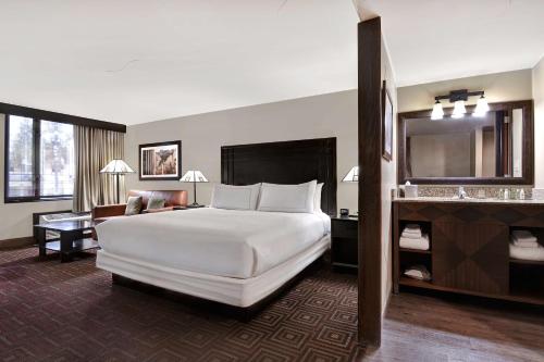 坦培凤凰城希尔顿逸林坦佩酒店的酒店客房设有一张白色大床和一张书桌