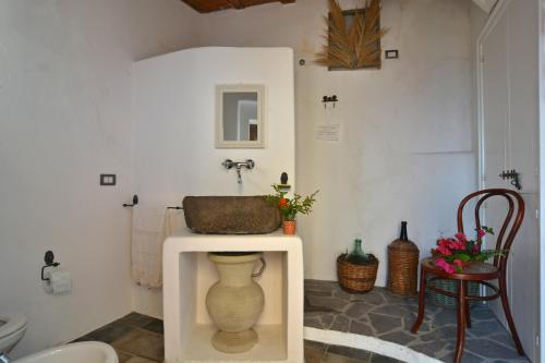 GinostraMariangelica的一间带水槽和桌子上的花瓶的浴室