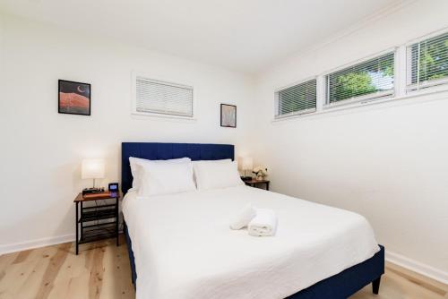 伯克利Lovely Landing Pad near Lambert Airport 3 bed bath的卧室配有一张白色大床和两个窗户
