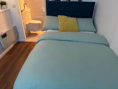 布里斯托Nice and Cosy Studio的卧室里一张带蓝色床头板的床