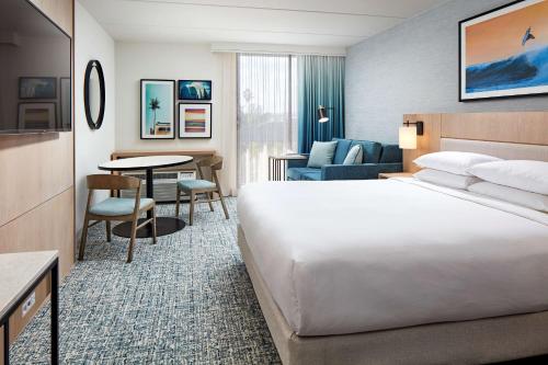 洛杉矶MDR玛丽安德尔湾希尔顿逸林酒店的酒店客房设有一张大床和一张桌子。