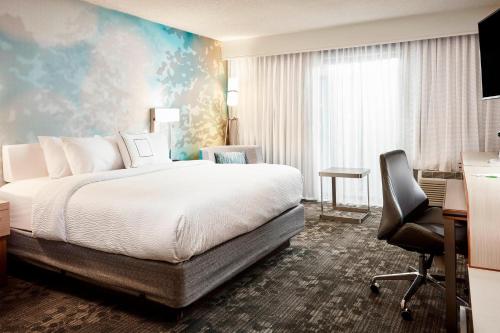 弗洛伦斯辛辛那提机场南/佛罗伦斯万怡酒店的一间卧室配有一张床、一张桌子和一把椅子