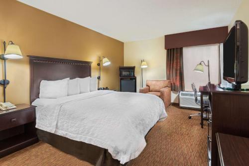 夏洛特夏洛特大学汉普顿酒店的配有一张床和一台平面电视的酒店客房