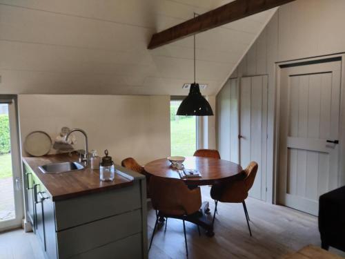 德文格洛Gastenverblijf Lheederhof的厨房配有桌椅和水槽。