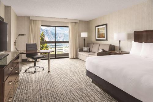 科罗拉多斯普林斯希尔顿逸林科罗拉多温泉酒店的酒店客房配有一张床、一张书桌和一张沙发。