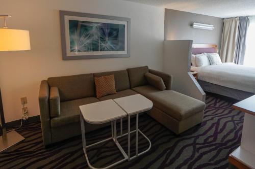 萨凡纳SpringHill Suites by Marriott Savannah Midtown的酒店客房设有一张沙发和一张床