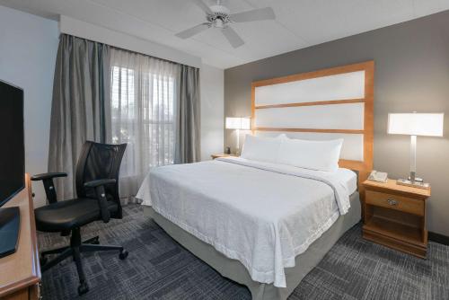 凤凰城凤凰城地铁中心霍姆伍德套房酒店的酒店客房配有一张床、一张桌子和一把椅子。