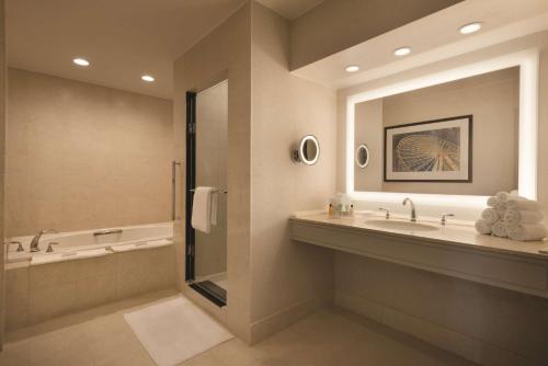 芝加哥Hilton Chicago Magnificent Mile Suites的带浴缸、水槽和镜子的浴室