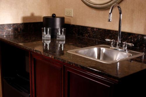 拉伯克拉伯克希尔顿合博套房酒店的厨房柜台配有水槽和玻璃杯