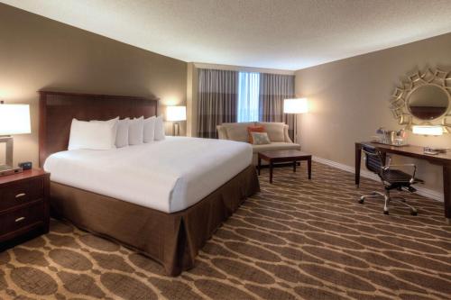 休斯顿休斯顿威斯契斯希尔顿酒店的酒店客房设有一张大床和一张书桌。