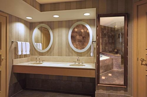 休斯顿休斯顿威斯契斯希尔顿酒店的浴室设有2个水槽和2面镜子