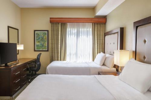克利尔沃特克利尔沃特希尔顿彼得斯堡套房酒店的酒店客房设有两张床、一张桌子和一台电视。