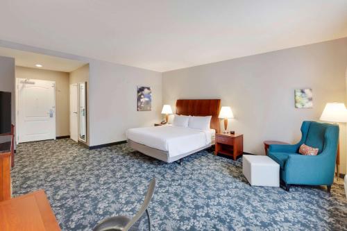 奥斯汀北奥斯丁希尔顿花园酒店的酒店客房,配有一张床和一张蓝色椅子