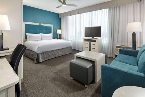 长滩长滩机场希尔顿惠庭套房酒店 的酒店客房配有床、沙发和电视。