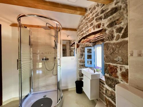 克尔克Villa Tona的带淋浴的浴室和石墙
