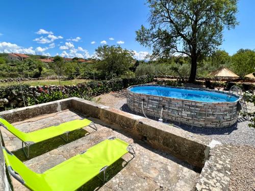 克尔克Villa Tona的一个带两把椅子的庭院和一个游泳池