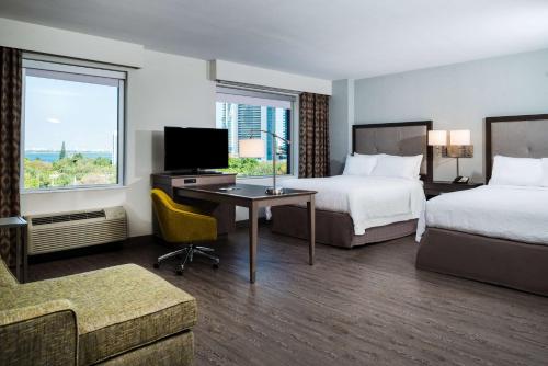 迈阿密Hampton Inn & Suites Miami Wynwood Design District, FL的酒店客房设有两张床、一张书桌和电视