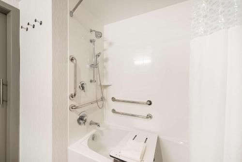 迈阿密Hampton Inn & Suites Miami Wynwood Design District, FL的白色的浴室设有浴缸和淋浴。