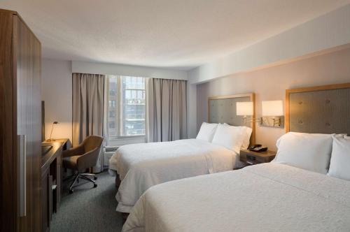 纽约曼哈顿切尔西汉普顿旅馆的酒店客房配有两张床和一张书桌