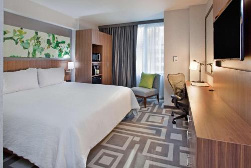 纽约Hilton Garden Inn New York Central Park South-Midtown West的酒店客房设有一张大床和一张书桌。