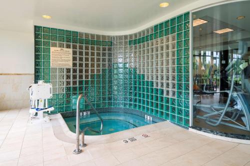 格拉斯顿伯里哈特福德南/格拉斯顿伯里希尔顿花园旅馆的绿色瓷砖浴室设有游泳池