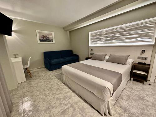 卡拉芭蒂纳Hotel El Paraíso的一间卧室配有一张大床和一张蓝色的沙发