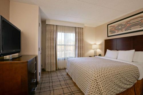 比奇伍德大使套房克利夫兰 - 比奇伍德酒店的配有一张床和一台平面电视的酒店客房