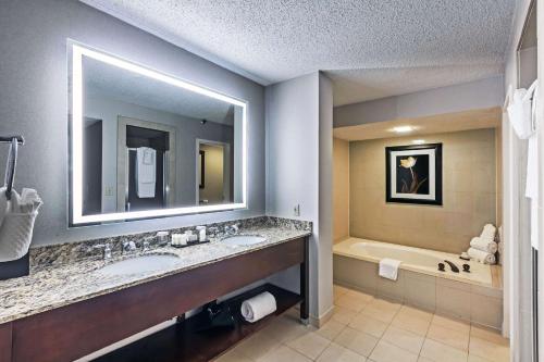 达拉斯Embassy Suites by Hilton Dallas Market Center的浴室配有两个盥洗盆和浴缸。