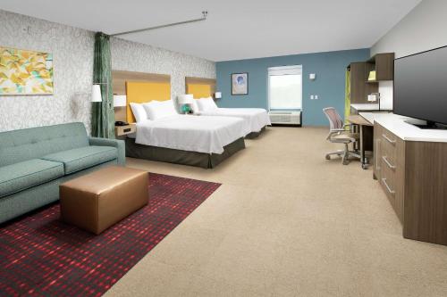 朗蒙特Home2 Suites By Hilton Longmont的酒店客房,配有床和沙发