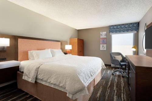 钱德勒凤凰城钱德勒汉普顿酒店的酒店客房设有一张大床和一张书桌。