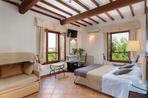 蒙特罗尼德阿尔比亚Hotel Ristorante Borgo Antico的一间卧室配有一张床、一张沙发和窗户。