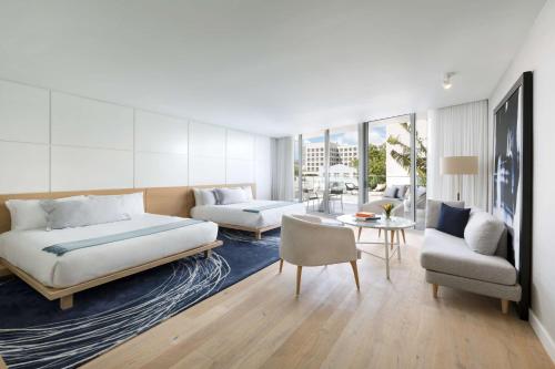 迈阿密海滩The Gabriel Miami South Beach, Curio Collection by Hilton的一间卧室设有一张床和一间客厅。