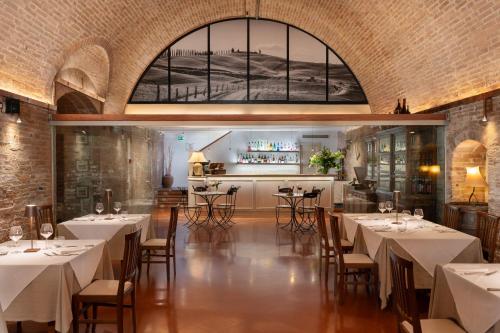 蒙特罗尼德阿尔比亚Hotel Ristorante Borgo Antico的一间在房间内配有桌椅的餐厅