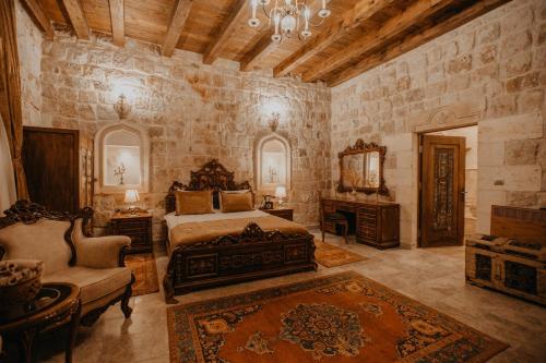 奥塔希萨尔Serenus Cave Suites的一间卧室配有一张床、一把椅子和镜子