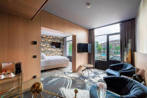 阿姆斯特丹Apollo Hotel Amsterdam, a Tribute Portfolio Hotel的酒店客房设有床和客厅。