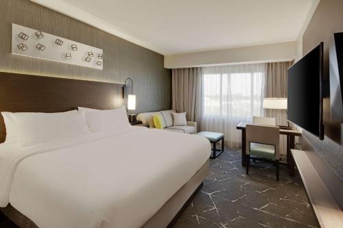 亚特兰大Embassy Suites by Hilton Atlanta Perimeter Center的酒店客房设有一张大床和一张书桌。