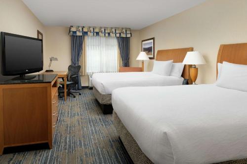亚基马Hilton Garden Inn Yakima Downtown的酒店客房设有两张床和一台平面电视。