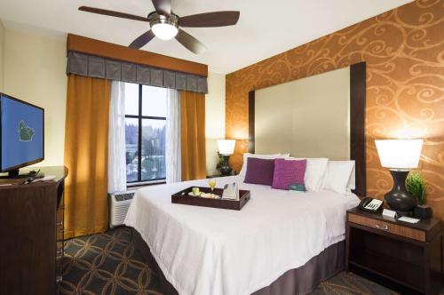 林伍德西雅图/林恩伍德希尔顿惠庭套房酒店的一间卧室配有一张大床和电视