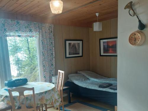 Lakeside Hilda, rantamökki的客房设有桌子、床和窗户。