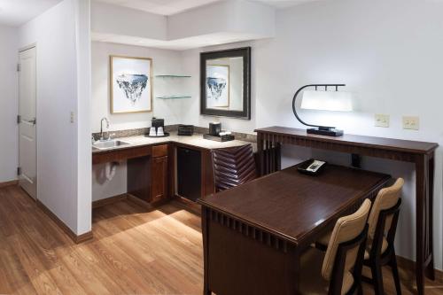 安克雷奇安克雷奇大使套房酒店的一间带书桌、水槽和桌子的浴室