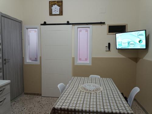 巴格里亚Holiday home La Rinascita的一间设有桌子的房间和墙上的电视