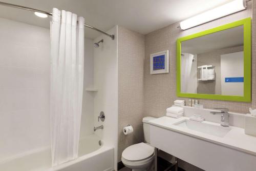 好莱坞劳德代尔堡机场汉普顿酒店及套房的浴室配有盥洗池、卫生间和镜子。