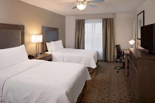 奥兰多Homewood Suites by Hilton Orlando Maitland的酒店客房设有两张床和电视。